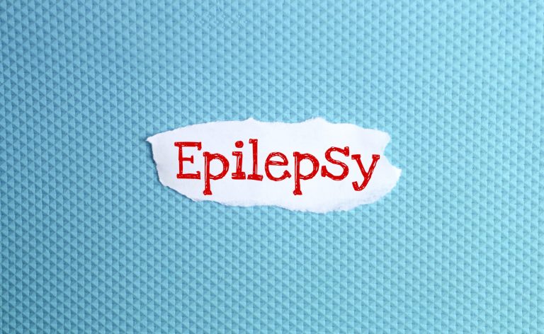 a torn paper written with inscription epilepsy on a blue background